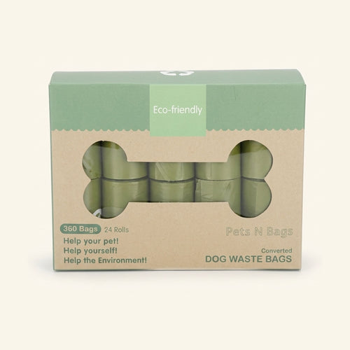 A green and brown box of eco-friendly dog waste bags with a bone-shaped cutout showing green rolls inside.