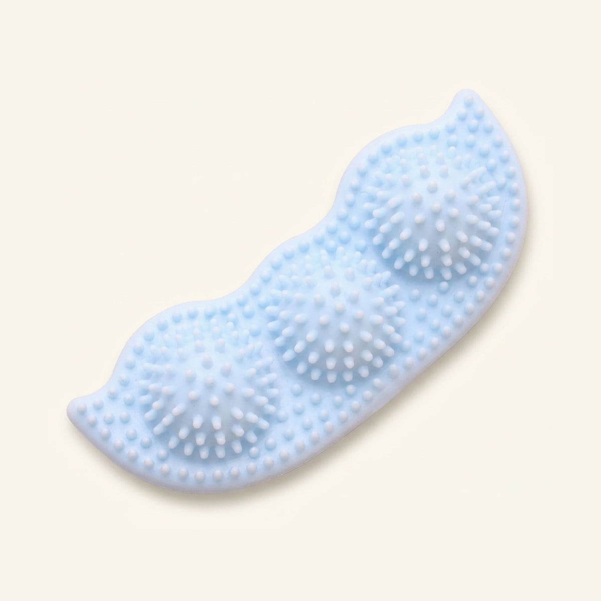A light blue, pea-pod-shaped rubber chew toy for dogs with a spiked texture on a cream background.