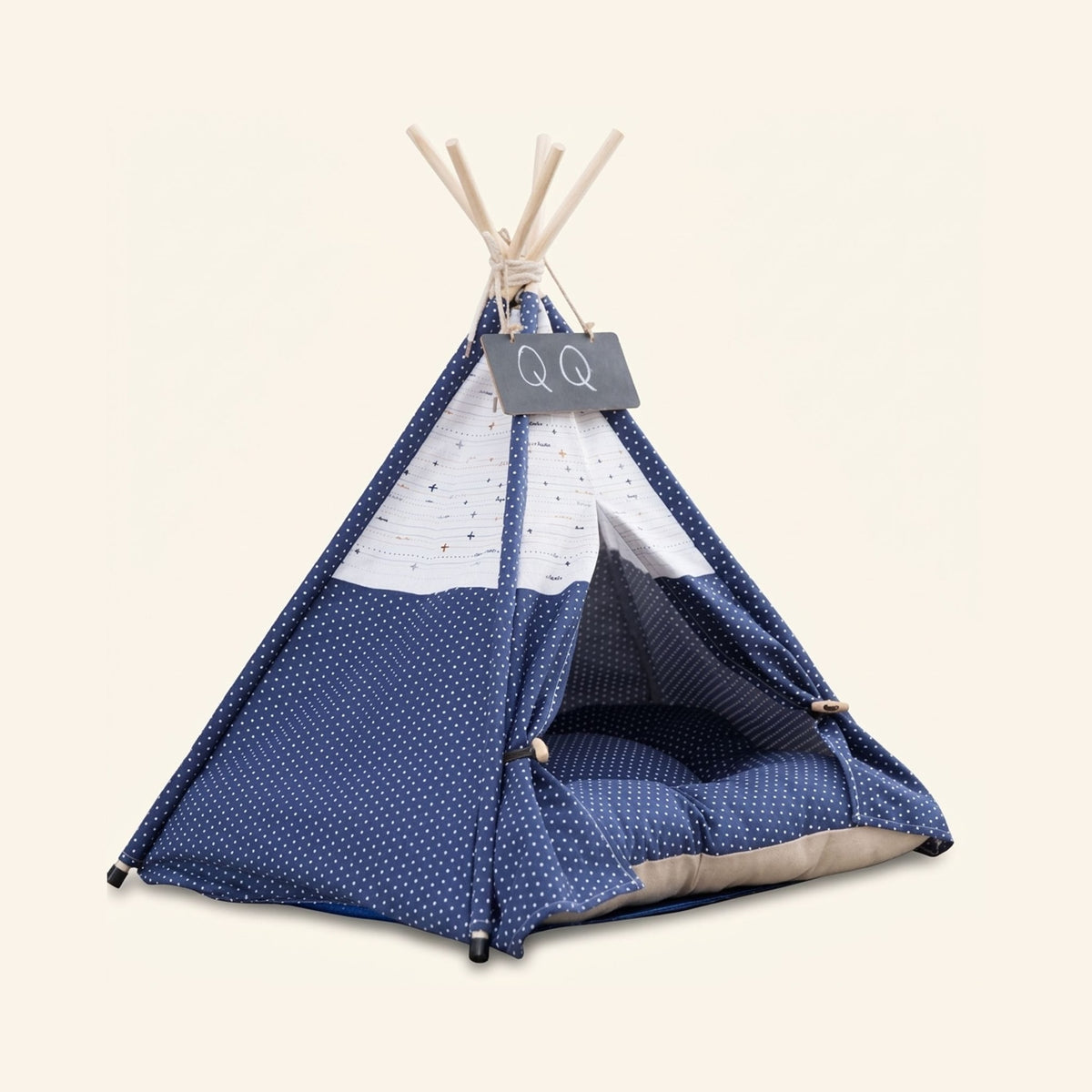 Navy blue pet teepee tent with white polka dots, five wooden support poles, and a matching inner cushion.