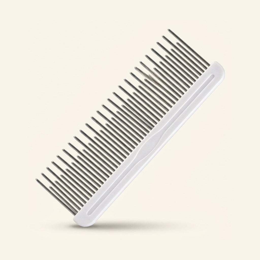A metal grooming comb with alternating long and short teeth and a white handle.