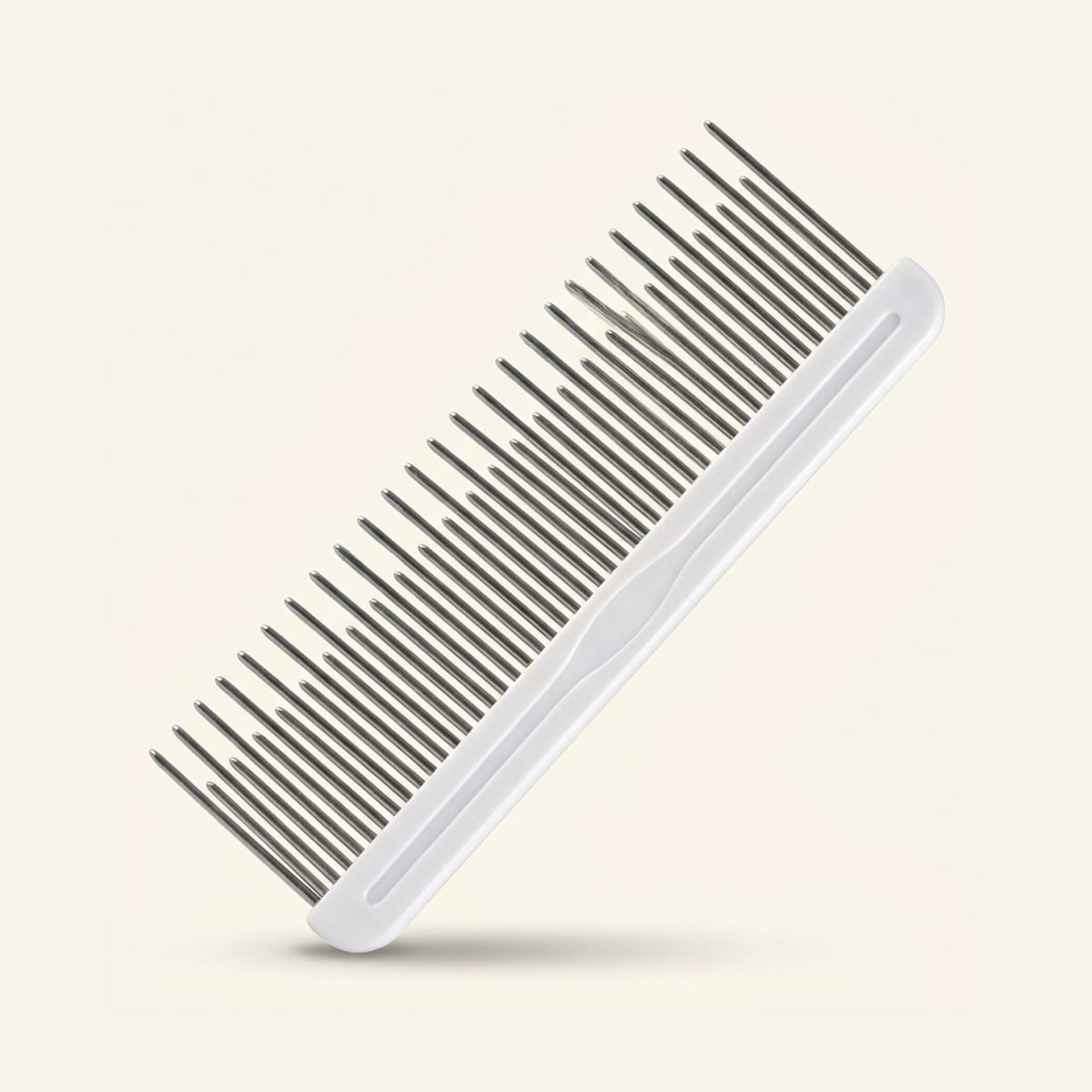 A metal grooming comb with alternating long and short teeth and a white handle.